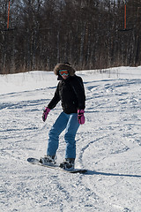 Image showing Woman doing exercise on snowboard in sunny day