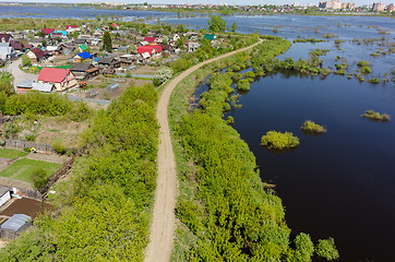 Image showing Dam separates residential area from spread river