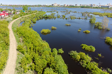 Image showing Dam separates residential area from spread river