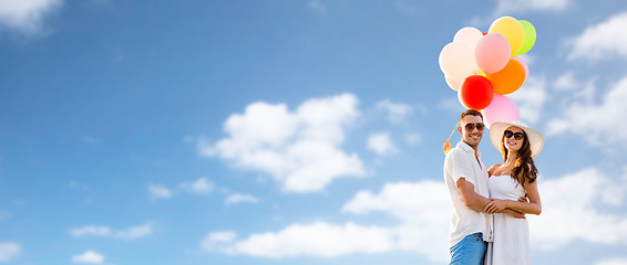 Image showing smiling couple with air balloons outdoors