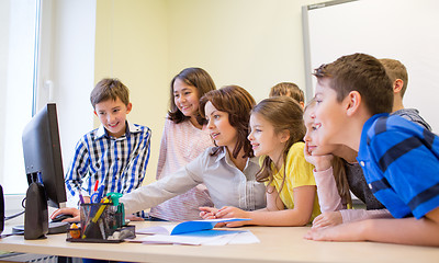 Image showing group of kids with teacher and computer at school