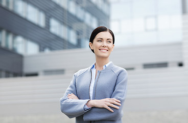 Image showing young smiling businesswoman over office building