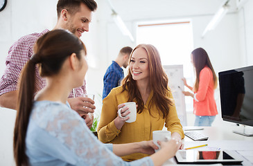 Image showing happy creative team drinking coffee at office