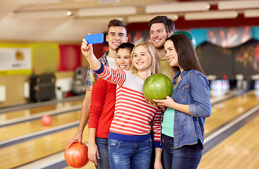 Image showing happy friends with smartphone in bowling club