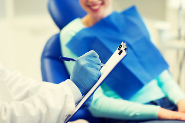 Image showing close up of dentist with clipboard and patient