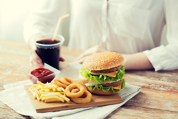 Image showing close up of woman with fast food and cola