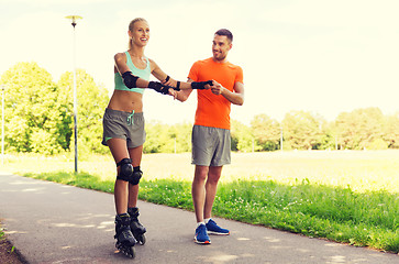 Image showing happy couple with roller skates riding outdoors