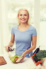 Image showing smiling woman cooking vegetable salad at home