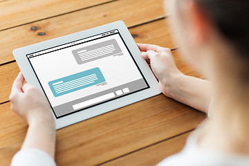 Image showing close up of woman with tablet pc on wooden table