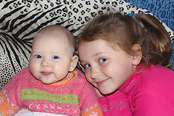 Image showing two little babies sisters lying on the bed