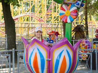 Image showing Six-year girl riding on a carousel, sitting in a stylized floret