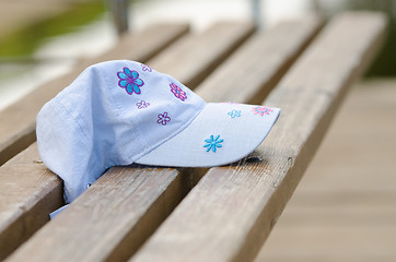 Image showing Forgotten cap girl lying on a bench