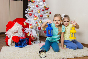 Image showing Two girls with flashlights waiting for Santa Claus at the Christmas tree in New Years Eve