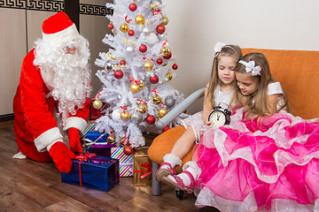 Image showing The two girls did not wait for Santa Claus and went to sleep, santa claus at this time put presents under the Christmas tree