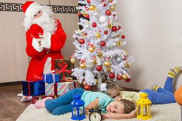 Image showing Santa Claus brought gifts for New Years Eve and softened faces of the two sleeping sisters