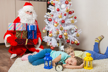 Image showing Santa Claus brought gifts for New Year\'s Eve and softened faces of the two sleeping sisters