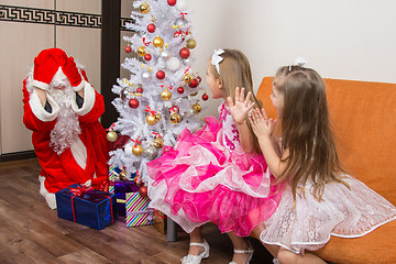 Image showing Two girls saw Santa Claus who brought them gifts