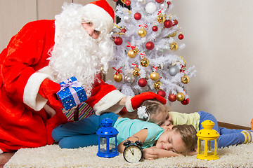 Image showing Santa Claus brought gifts, pats on the head of sleeping children, and looked into the frame