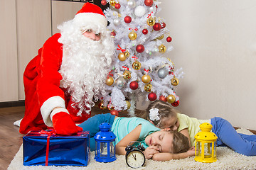 Image showing Santa Claus in New Years Eve puts the gift in front of sleeping sister