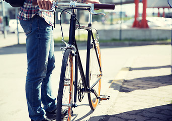 Image showing close up of man and fixed gear bike on city street