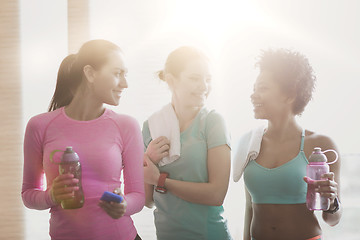 Image showing happy women with bottles of water in gym