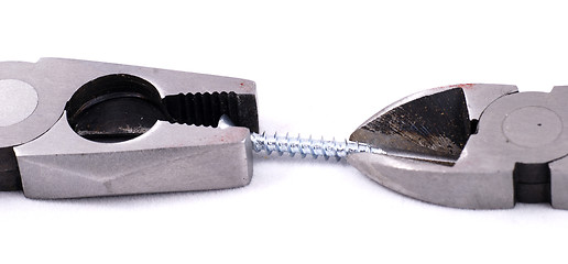 Image showing Pliers and cutter handling a screw