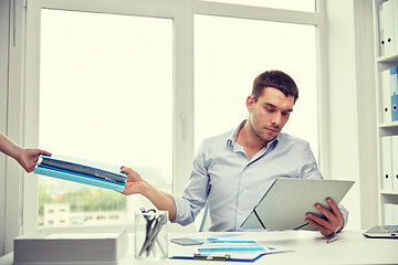 Image showing businessman taking papers from secretary in office