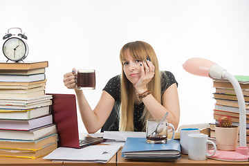 Image showing Girl student looked sadly into the frame sitting with a cup of coffee in hand