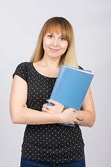 Image showing The girl is with a smile and holds folder with documents to his chest