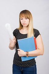 Image showing Half-length portrait of a young girl with folders and a roll of paper in his hands