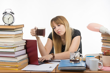 Image showing Student falls asleep with a mug of coffee in hand, working in a laptop