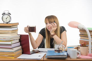 Image showing Girl student doing night sadly looks at another cup of coffee