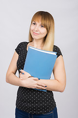 Image showing Girl with a dreamy look standing with folders in hands