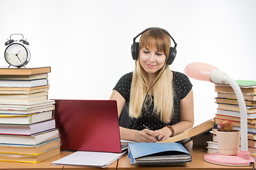 Image showing Student with headphones ready to pass the diploma project is looking for information on the Internet