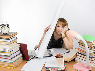 Image showing Tired student sitting at the table and put a figure to the head