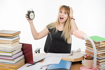 Image showing A student with an alarm clock in hands understand that slept exam