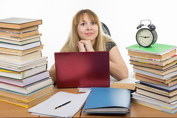 Image showing Disheveled student sitting at the table and looking at the frame