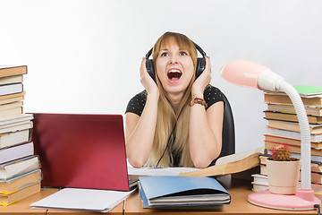 Image showing A student shouts from fatigue while listening to music on headphones