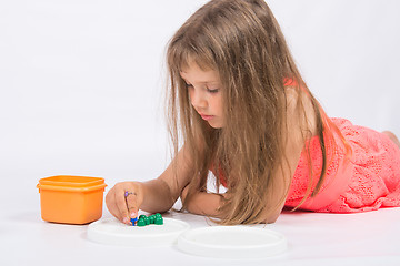 Image showing Five-year girl collects mosaic lying on the floor