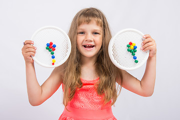 Image showing Girl shows colorful flowers collected from the mosaic