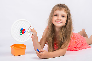 Image showing Girl shows a mosaic with unfinished flower