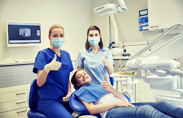 Image showing happy female dentist with patient girl at clinic