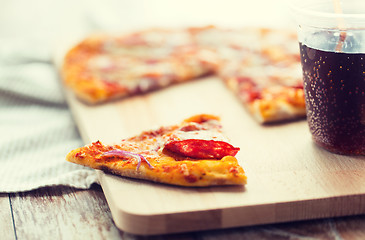 Image showing close up of pizza with carbonated drink on table