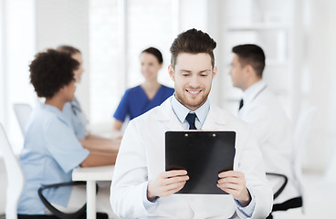 Image showing happy doctor with tablet pc over team at clinic