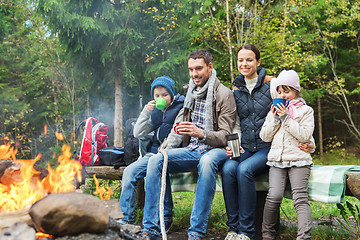 Image showing happy family sitting on bench at camp fire