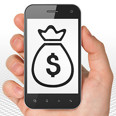 Image showing Banking concept: Hand Holding Smartphone with Money Bag on display