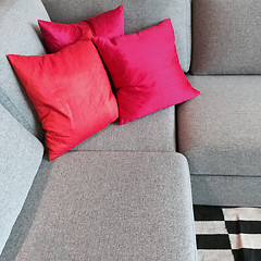 Image showing Gray corner sofa with silky red cushions
