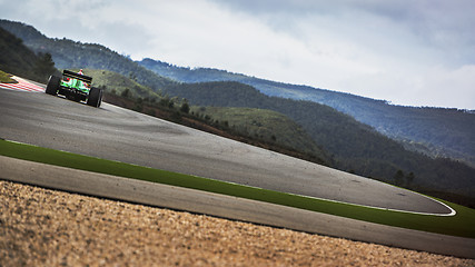 Image showing racing on the track between the hills in a formula race car