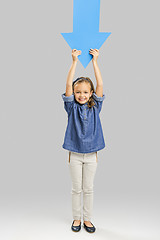 Image showing Girl holding a big blue arrow