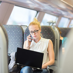 Image showing Business woman working while travelling by train.